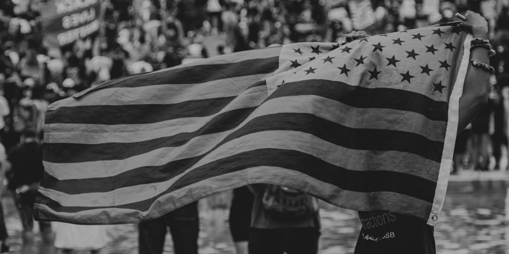 Black and white close up of the American flag being held up at a BLM march in Washington, D.C.