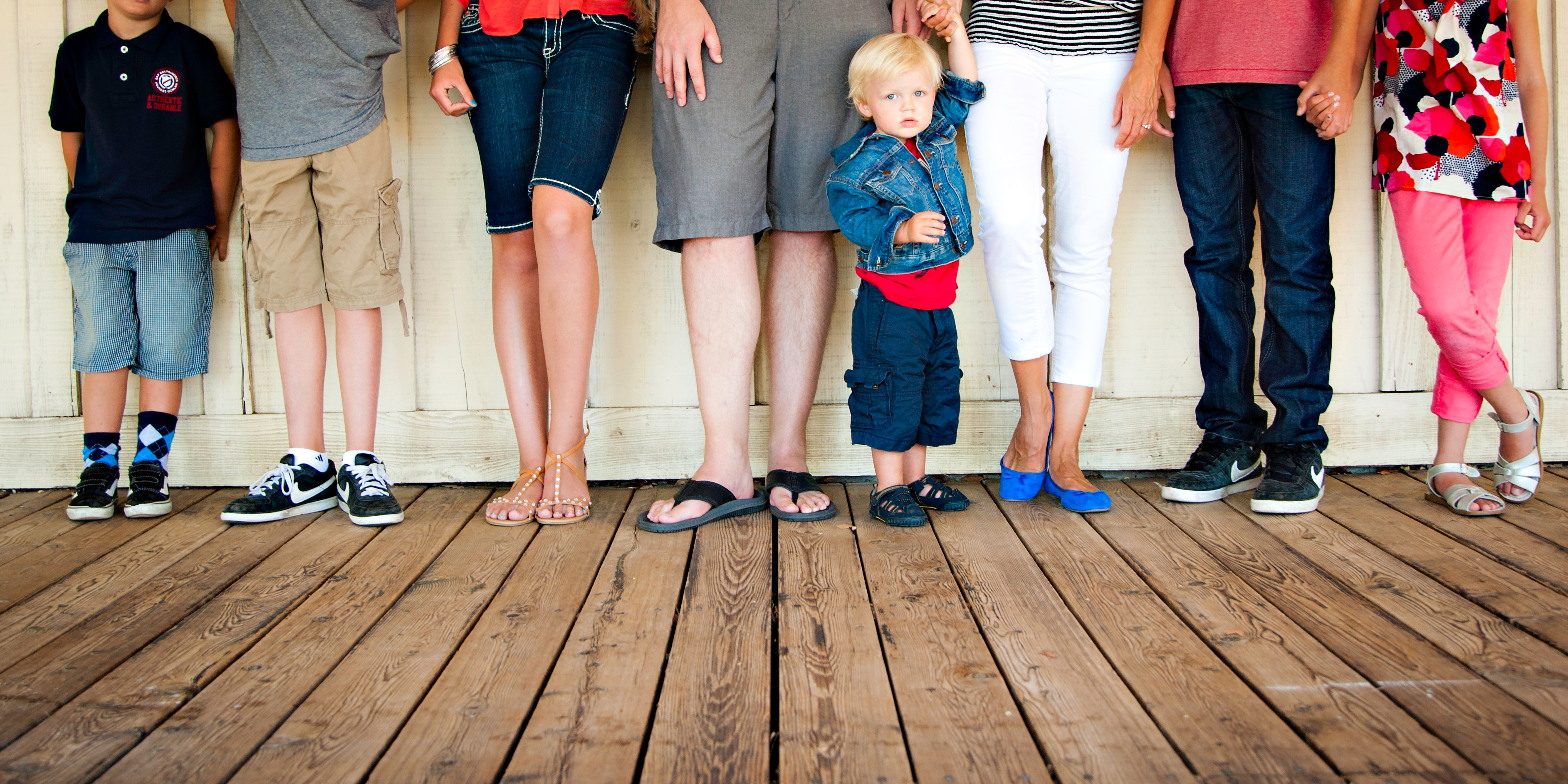 A cropped image of a group photo showing only legs and feet.